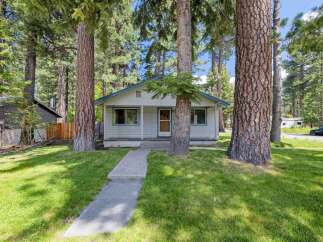 Nestled amongst towering trees, this charming home offers a serene escape.