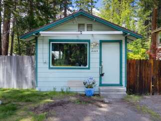 Charming cottage-style home nestled in a serene, tree-lined setting.