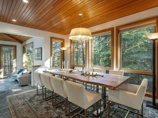 Experience luxury dining in this stunning property, featuring a spacious dining area with a beautiful wooden table and elegant seating.