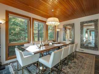 Step into luxury with this stunning dining room, featuring a beautiful wooden table and elegant white chairs.