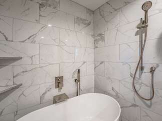 Step into luxury with this stunning bathroom featuring exquisite marble-look tile.