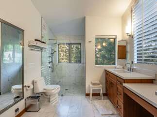 Step into luxury with this stunning bathroom featuring a spacious walk-in shower, elegant marble tile, and a modern vanity.
