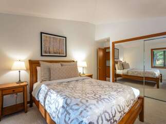 This inviting bedroom features a comfortable bed with stylish bedding, perfect for a relaxing retreat.