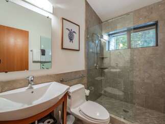 This modern bathroom features a sleek design with a glass-enclosed shower and a stylish sink.