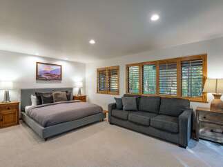 This spacious bedroom offers a serene retreat with its neutral color palette and ample natural light.