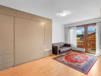 Discover this charming property featuring a cozy living space with a comfortable sofa and a vibrant rug.