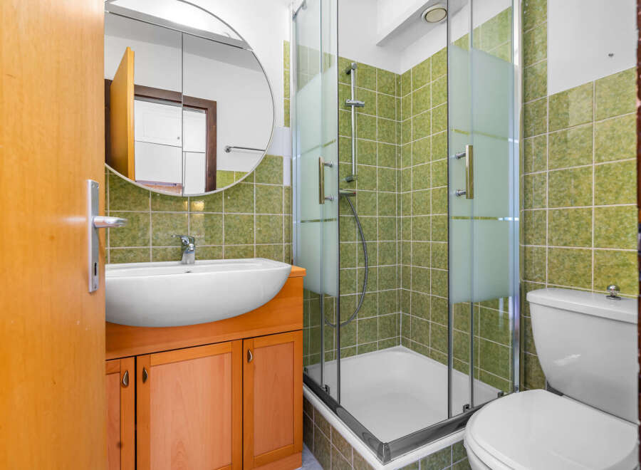 This bathroom features a modern design with a sleek sink and a spacious shower.