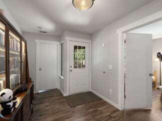 Step into this inviting entryway, showcasing beautiful hardwood floors and a well-lit space.