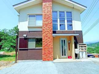 Discover this charming two-story home featuring a striking brick chimney and a welcoming facade.