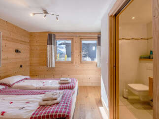 This charming bedroom features two cozy beds with red and white plaid bedding, perfect for a restful night's sleep.