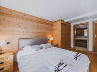 Experience rustic charm in this beautifully appointed bedroom featuring warm, natural wood paneling throughout.