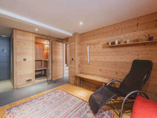 Experience ultimate relaxation in this luxurious spa area, featuring a traditional Finnish sauna with glass doors and ample wooden benches.