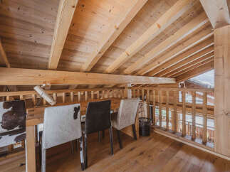 Experience rustic charm in this loft space, featuring a warm wooden interior with exposed beams and a sloped ceiling.