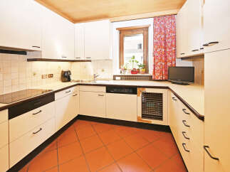 Discover this charming kitchen featuring sleek white cabinetry and a durable tile backsplash.