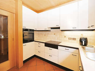 This modern kitchen features sleek white cabinetry and a built-in Bosch oven, perfect for any home chef.
