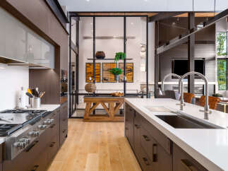 Experience luxury living in this modern kitchen featuring dark wood cabinetry and sleek stainless steel appliances.