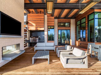 Experience luxurious outdoor living with this stunning covered patio, featuring a built-in grill and a modern fireplace.