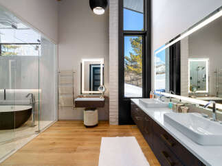 Experience luxury in this modern bathroom featuring a freestanding soaking tub within a glass-enclosed shower.