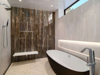 Indulge in luxury with this stunning modern bathroom featuring a sleek freestanding bathtub and a spacious walk-in shower.
