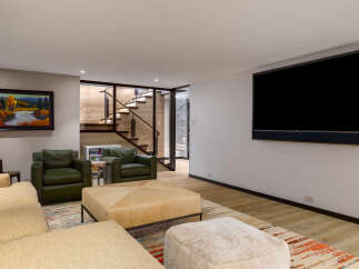 Experience modern living in this stylish living room, featuring plush seating and a large flat-screen TV perfect for entertainment.