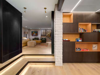 Experience modern living in this stunning home featuring a sleek, dark accent wall and illuminated staircase.