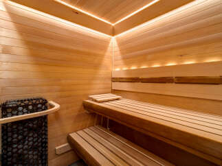 Experience ultimate relaxation in this luxurious wooden sauna, featuring ambient LED lighting that enhances the warm, natural wood tones.