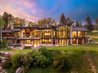 Experience luxury living in this stunning modern home, featuring expansive glass walls that invite natural light and offer breathtaking views.