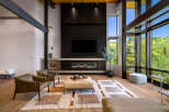 Experience luxury living in this stunning modern living room, featuring a dramatic floor-to-ceiling fireplace and expansive windows that showcase breathtaking mountain views.