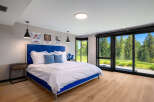 Experience ultimate comfort in this modern bedroom featuring a plush blue upholstered bed and crisp white linens.