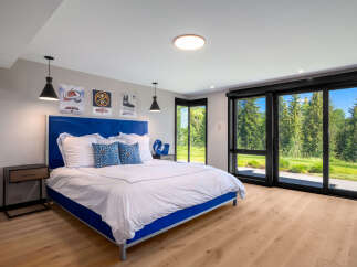 Experience ultimate comfort in this modern bedroom featuring a plush blue upholstered bed and crisp white linens.