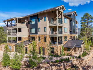 Experience luxury mountain living in this stunning multi-story residence, featuring expansive balconies with breathtaking views and a stone-accented facade.