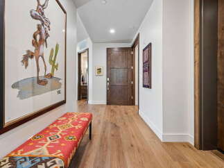 This hallway features a unique artistic touch with a framed cartoon coyote print and a vibrantly patterned bench.