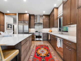 Experience luxury in this modern kitchen featuring rich walnut cabinetry and sleek stainless steel appliances.