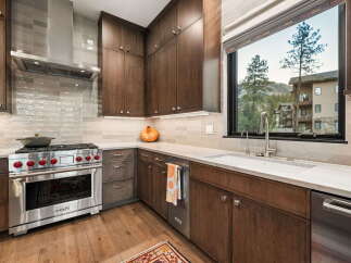 Experience luxury in this modern kitchen featuring dark wood cabinetry and a sleek stainless steel range.