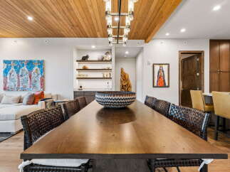 Experience elegant dining in this spacious room featuring a large wooden table and comfortable seating, perfect for gatherings.