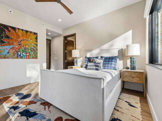 Experience luxurious comfort in this master bedroom, featuring a plush upholstered bed and a striking Native American-inspired artwork.