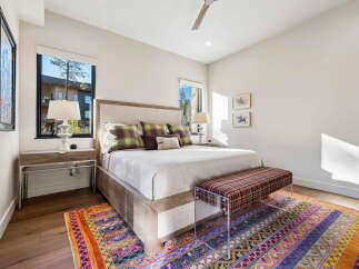 Experience luxurious comfort in this master bedroom, featuring a king-sized bed adorned with plush pillows and a stylish upholstered headboard.
