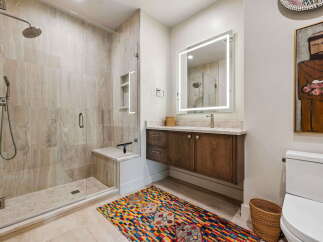 Experience modern luxury in this stunning bathroom, featuring a spacious walk-in shower with elegant tilework and a built-in bench.