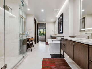 Experience luxury in this stunning master bathroom, featuring a spacious walk-in shower with a rainfall showerhead and a freestanding soaking tub perfect for relaxation.
