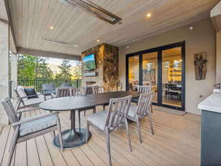 Enjoy outdoor living at its finest on this expansive covered deck, complete with a stone fireplace and a mounted television for ultimate entertainment.