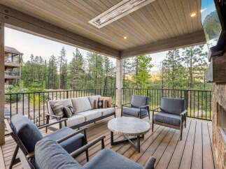 Experience luxurious outdoor living on this expansive covered deck, perfect for entertaining or relaxing amidst stunning mountain views.