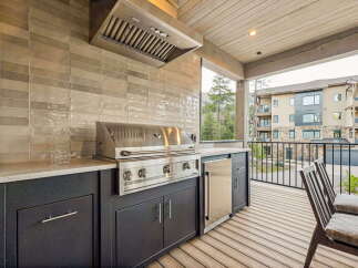 Experience outdoor living at its finest with this modern built-in grill station, complete with a sleek stainless steel grill and integrated mini-fridge.