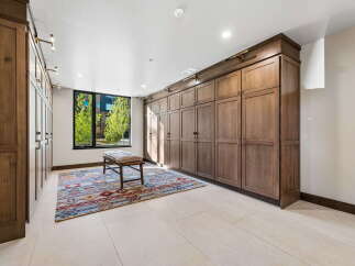 Discover ample storage solutions in this spacious room, featuring floor-to-ceiling custom wood cabinetry perfect for organizing your belongings.