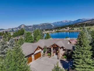 Experience luxury living with this stunning mountain estate, featuring a spacious home with a grand entrance and a three-car garage.