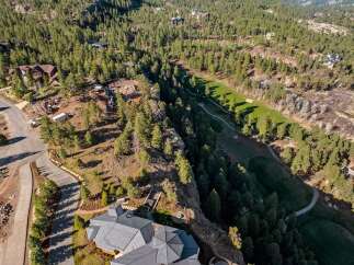 Experience luxury living nestled amidst a serene forest landscape with this stunning aerial view.