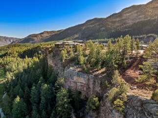Experience unparalleled luxury with this stunning cliffside estate, offering breathtaking panoramic views of the surrounding mountains and lush forests.