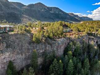Experience unparalleled luxury with this stunning cliffside estate, offering breathtaking panoramic views of the surrounding mountains and lush forests.
