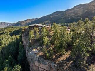 Experience unparalleled luxury with this stunning cliffside estate, offering breathtaking panoramic views of the surrounding mountains and lush forests.