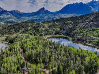 Discover your dream mountain retreat nestled amidst lush forests and a serene lake.