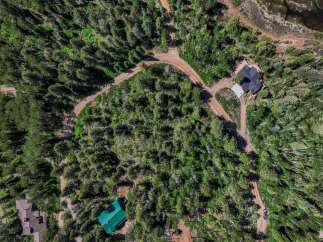 Discover this stunning aerial view of a secluded property nestled within a lush forest.